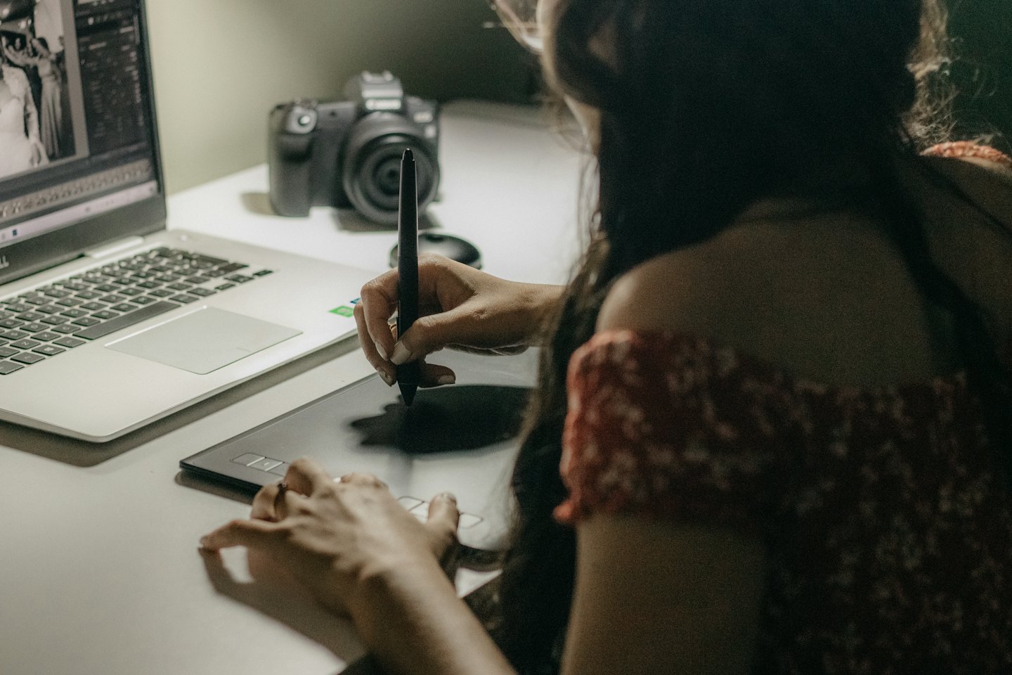 Graphic designer working on a laptop with a stylus.